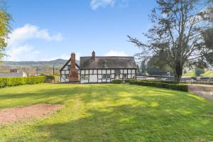 2 Bed in Shelsley Walsh oc-t30222 في Shelsley Walsh: منزل قديم باللونين الأبيض والأسود مع ساحة كبيرة