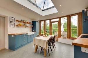 a kitchen with blue cabinets and a table with chairs at 5 Bed in Guestwick oc-2199 in Guestwick