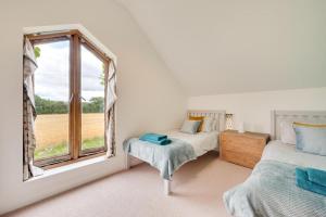 a bedroom with two beds and a window at 5 Bed in Guestwick oc-2199 in Guestwick
