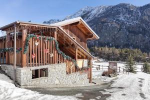 una baita nella neve con decorazioni natalizie di La Baita - Bionaz a Dzovenno