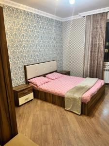 a bedroom with a large bed in a room with blue wallpaper at Apartment city in Baku