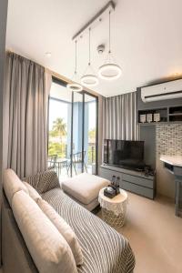 a living room with a couch and a television at The Kamala View in Kamala Beach
