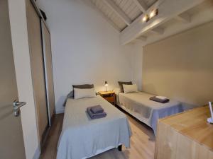 a room with two beds and a table with a lamp at Álamos de los Andes - Andarlibre in San Martín de los Andes +144 photos