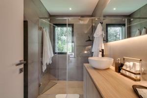 a bathroom with a sink and a glass shower at Ocean & Pool Retreat Villa by HostWise in Amoreira
