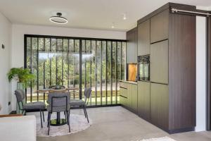 a kitchen with a table and chairs and a large window at Ocean & Pool Retreat Villa by HostWise in Amoreira