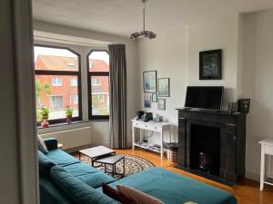 a living room with a blue couch and a fireplace at Rue Haute by M&M 4 sterren bed en breakfast vlakbij Maastricht in Eben-Emael