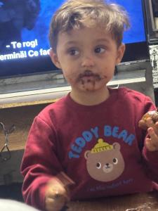 un ragazzino con del cibo in faccia di Villa hemciu a Cluj-Napoca