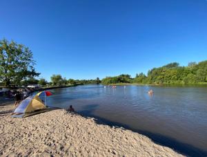 una persona con una tenda sulla riva di un fiume di Village Coast a Villa María