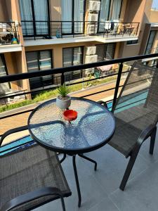 een glazen tafel en 2 stoelen op een balkon bij Two Bedroom Kyrenia in Kyrenia +4 foto's