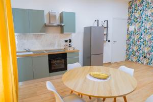 een keuken met een houten tafel en witte stoelen bij LIONS ROOMS Augusta in Augusta