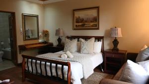 LUXURY ROOM @ 4 STAR GUEST HOUSE في ميدلبرغ: غرفة نوم بها سرير ومرآة