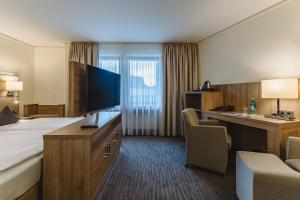 a hotel room with a bed and a desk at Hotel Gustav-Stresemann-Institut in Bonn