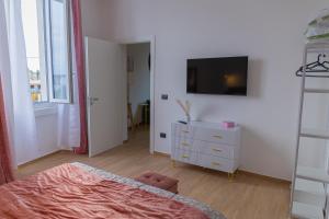 een slaapkamer met een bed en een tv aan de muur bij LIONS ROOMS Augusta in Augusta