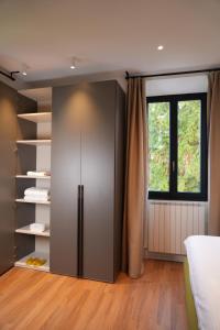 a room with a closet with a refrigerator and a window at Palmarea House in Nebbiuno