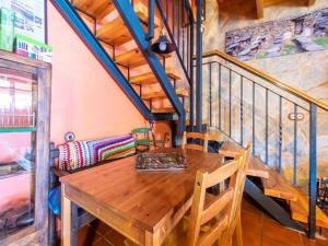 Tranquil Stay Near Luna River في Benllera: طاولة وكراسي خشبية في غرفة بها درج