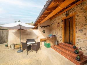 Tranquil Stay Near Luna River في Benllera: فناء فيه مظلة وكراسي وطاولة