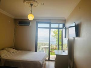 a bedroom with a bed and a window with a view at CANPOLAT Sapanca Hotel in Sapanca +28 photos