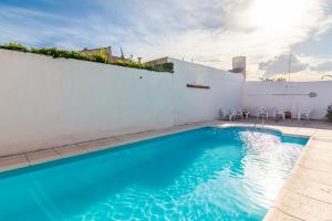 a swimming pool with blue water on a white wall at HOSTERIA NIDO DE CONDORES-Solo Adultos in Mina Clavero