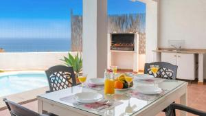 ein Esszimmer mit einem Tisch und einem Pool in der Unterkunft Villa Paraiso Torrox by Ruralidays in Torrox