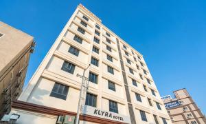 een hoog wit gebouw met een bord erop bij Klyra Hotel in Hyderabad