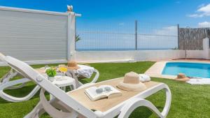 ein Tisch und Stühle neben einem Swimmingpool in der Unterkunft Villa Paraiso Torrox by Ruralidays in Torrox