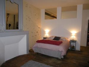 a bedroom with a bed with two lamps and a mirror at Le MONSEG in La Celle-sous-Gouzon