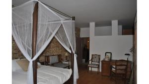 a bedroom with a canopy bed with a desk and chairs at Le MONSEG in La Celle-sous-Gouzon