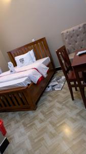 UyoleBeita Executive Lodge的一间卧室，里面有一张床、一张桌子和一把椅子