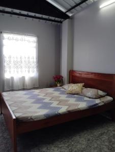 Una cama grande en un dormitorio con ventana. en B5 Homestay, en Shillong