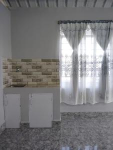 Habitación con cortina blanca y ventana en B5 Homestay, en Shillong