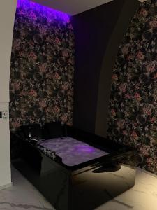 Ein Zimmer mit einem lila Sofa und einer Wand mit Blumen in der Unterkunft Kari Suite in Sammichele di Bari + 21 Fotos