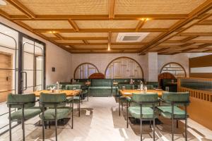 een restaurant met houten tafels en groene stoelen bij Klyra Hotel in Hyderabad