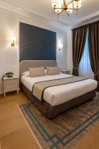 Un dormitorio con una cama grande y una lámpara de araña. en Hotel Dandy Rouen centre, en Rouen