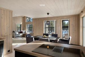 a living room with wooden walls and tables and chairs at Trysilfjell hytteomrade 2124 by Vacation Trysil in Hovi