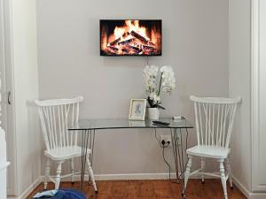 2 Seconds Avenue في هيلتون: طاولة مع كرسيين ومدفأة على الحائط
