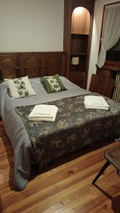 een slaapkamer met een bed met twee handdoeken erop bij Ca' Donatella - Mountain View Terrace & Parking in Cortina dʼAmpezzo