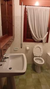 een badkamer met een wastafel en een toilet en een raam bij Ca' Donatella - Mountain View Terrace & Parking in Cortina dʼAmpezzo +17 foto's