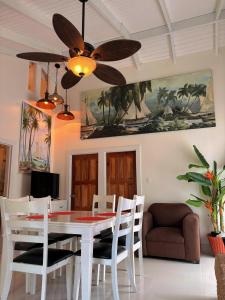 Caye Caulker Boutique Guesthouse 1 في كاي كولكر: غرفة طعام مع طاولة بيضاء ومروحة سقف