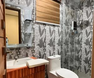 um banheiro com vaso sanitário e pia em Ranch-o-tel Guesthouse em Sampong