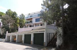 een wit gebouw met groene deuren en trappen aan de voorkant bij Global Immo 9101 Pacheco Beach in Roses