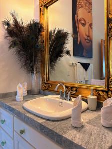 Caye Caulker Boutique Guesthouse 1 في كاي كولكر: حمام مزود بحوض ومِرآة