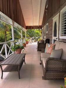 Caye Caulker Boutique Guesthouse 1 في كاي كولكر: شرفة مع أريكة وطاولة وكراسي
