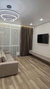 een woonkamer met een bank en een flatscreen-tv bij Amal in Zhezdi