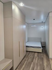 een slaapkamer met een bed en witte kasten bij Amal in Zhezdi +4 foto's