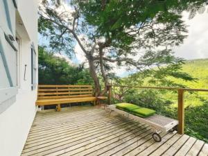 eine Holzterrasse mit einer Bank und einem Baum in der Unterkunft Villa with Private Pool in Upper Prince's Quarter in Dawn Beach