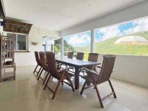 ein Esszimmer mit Tisch und Stühlen und einem großen Fenster in der Unterkunft Villa with Private Pool in Upper Prince's Quarter in Dawn Beach