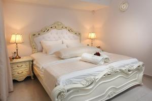Una cama blanca en un dormitorio con dos lámparas. en Moses Luxury apartments -nobility, en Safed