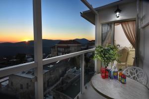 una mesa en un balcón con vistas a la puesta de sol en Moses Luxury apartments -nobility, en Safed