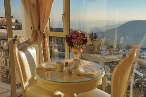 Una mesa de cristal con un jarrón de flores sobre una mesa. en Moses Luxury apartments -nobility, en Safed