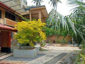 una casa con un árbol delante de un edificio en Liyans Eco Villa, en Habaraduwa Central